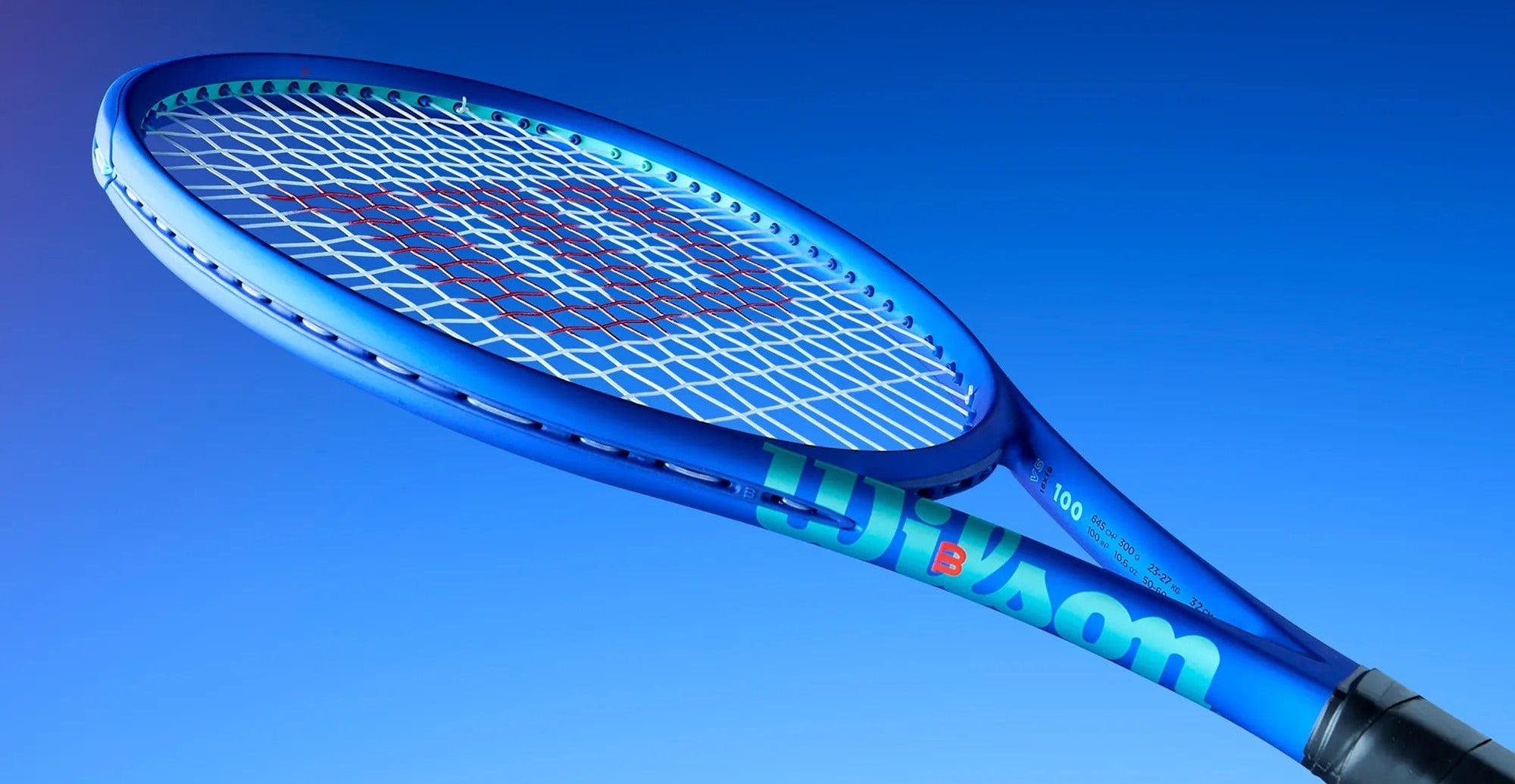 Blue tennis racket with Wilson branding against a blue background